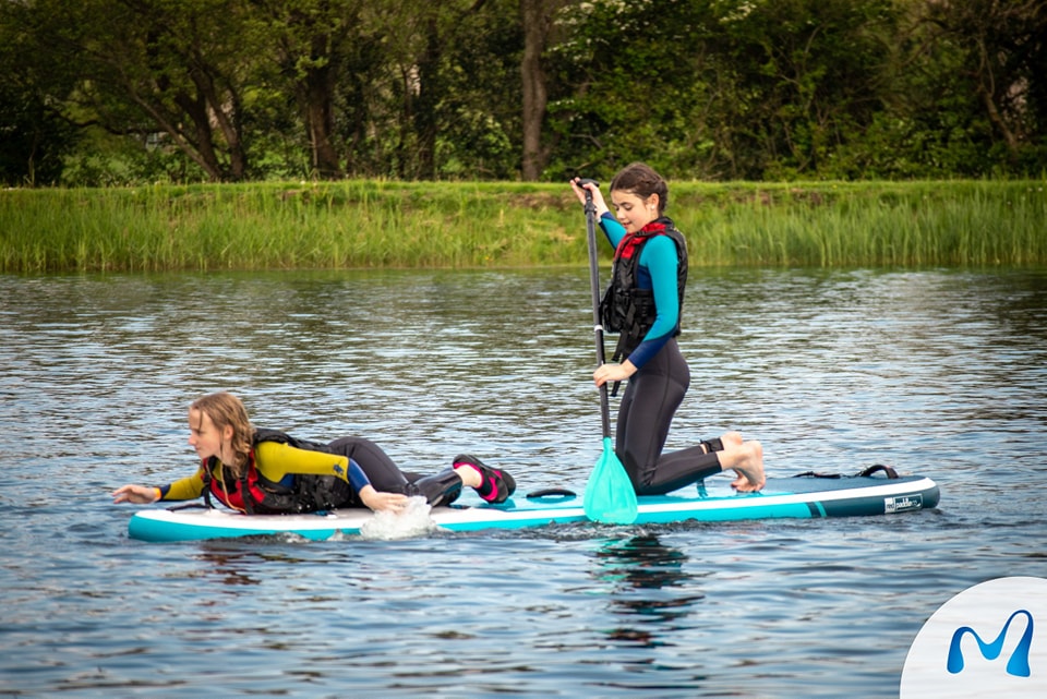Two participants splashing and paddleboarding at Moira Lakes