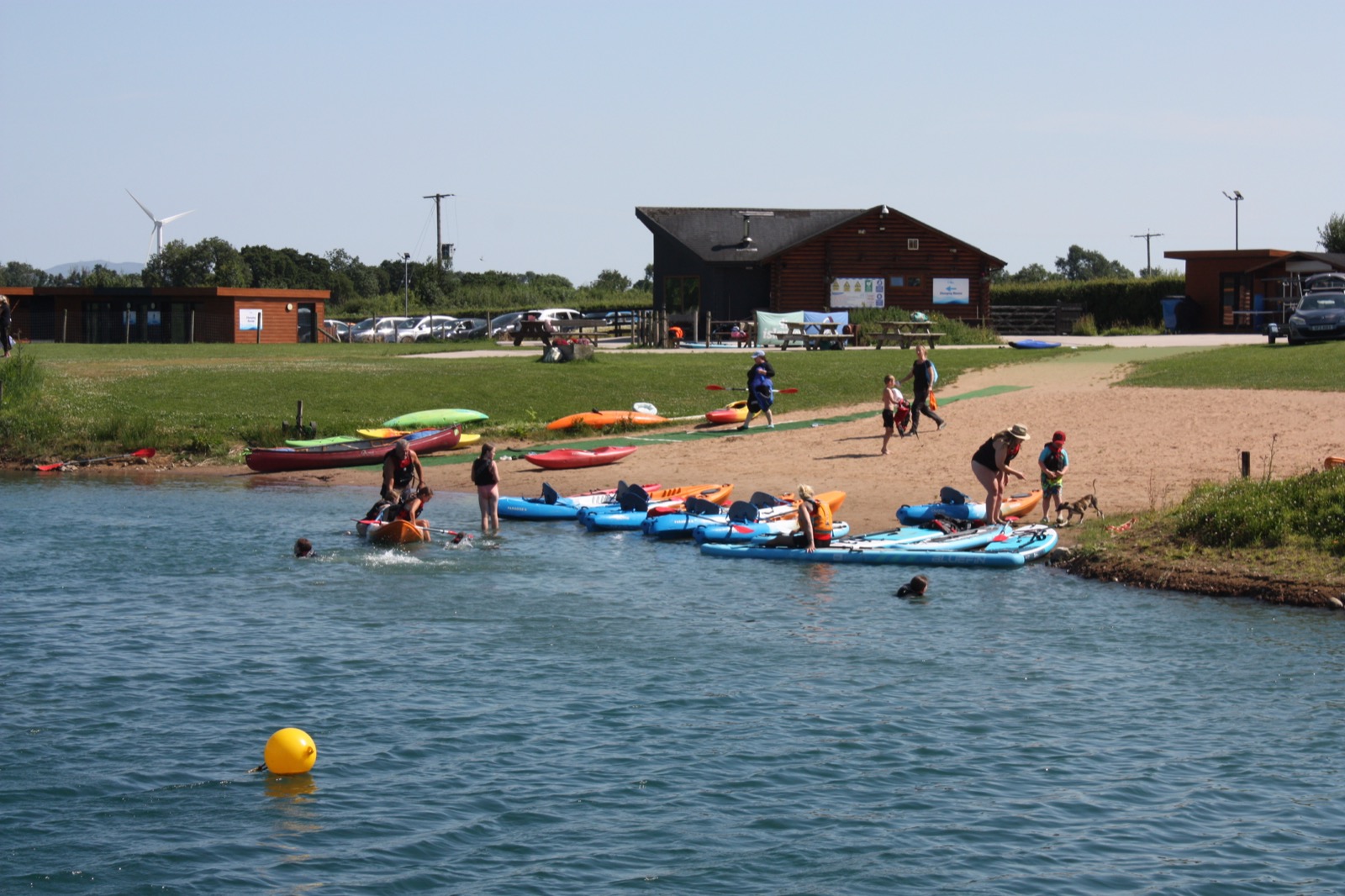 The lakeside lawn, picnic tables and timber clubhouse at Moira Lakes